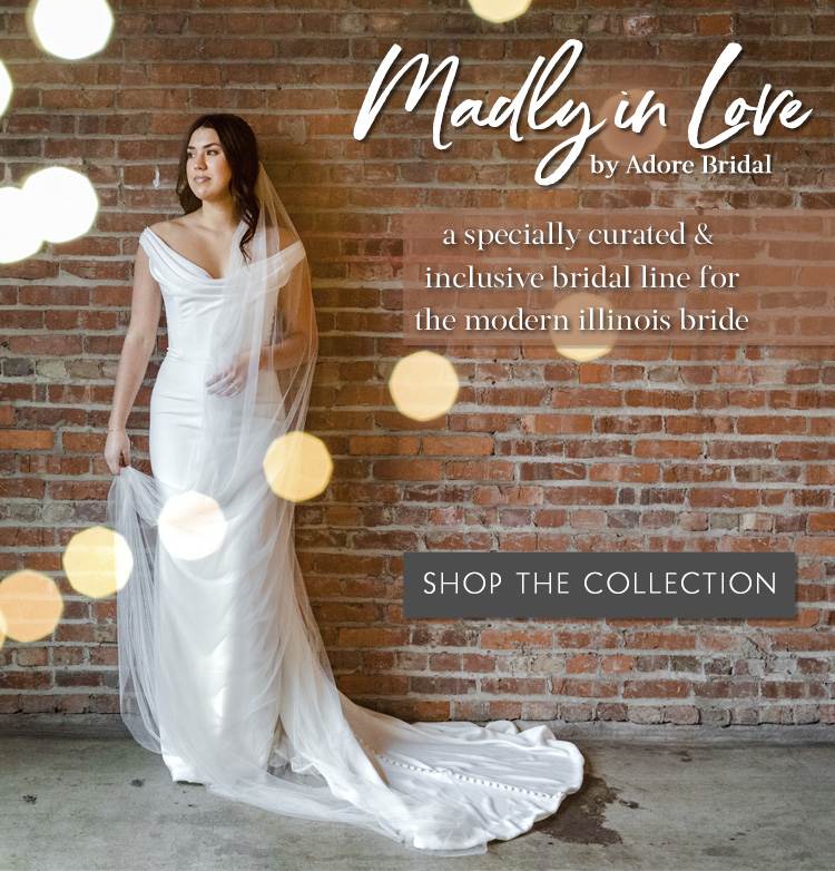 Bride wearing simple gown standing in front of a brick wall